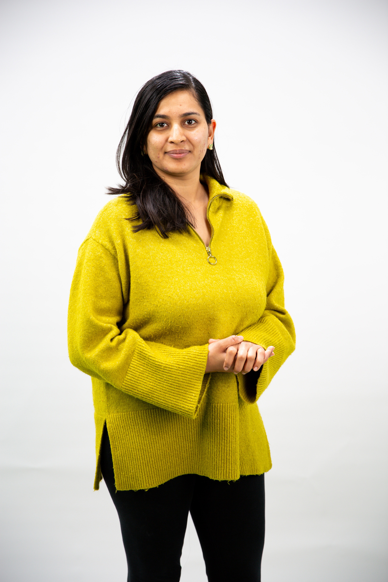 Woman with black hair and a yellow sweater